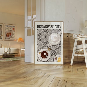 Puede incluir: Un p&oacute;ster en blanco y negro con el texto "Breakfast Tea" en una fuente decorativa. El p&oacute;ster presenta una tetera blanca y una taza de t&eacute; con flores sobre un fondo de azulejos con patrones.