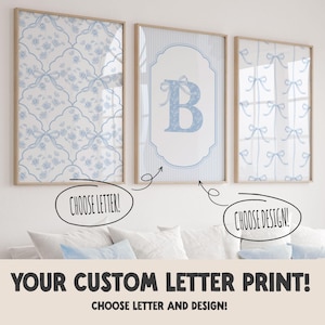May include: Three framed prints with light blue floral, bow, and letter designs. The center print features the letter "B" with a bow. The text "CHOOSE LETTER!" and "CHOOSE DESIGN!" are included. The text "YOUR CUSTOM LETTER PRINT!" is also included.