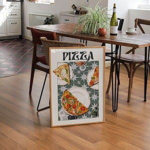 May include: A framed print of a pizza illustration with the word "PIZZA" in a retro font. The pizza slices are on white plates with a green and white tiled background.
