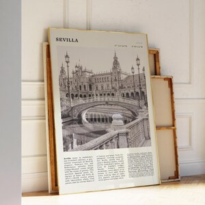 May include: A framed black and white print of Seville, Spain, featuring a detailed architectural image of a bridge and buildings. The print has a gold frame and includes the city's name and descriptive text.