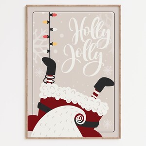 Puede incluir: Una ilustraci&oacute;n digital de Pap&aacute; Noel colgado boca abajo con el texto "Holly Jolly" sobre un fondo beige.  Pap&aacute; Noel lleva un traje rojo con ribetes blancos y botas negras.  Est&aacute; sujetando una cadena de luces navide&ntilde;as.