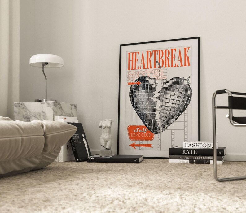 Pode incluir: Uma ilustra&ccedil;&atilde;o em preto e branco de um cora&ccedil;&atilde;o partido em forma de bola de discoteca. O texto "HEARTBREAK" est&aacute; em letras vermelhas acima do cora&ccedil;&atilde;o. Abaixo do cora&ccedil;&atilde;o h&aacute; uma placa que diz "Self Love Club".