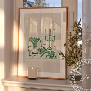 Puede incluir: Una impresi&oacute;n enmarcada de un dibujo de l&iacute;nea verde de una mesa puesta con un candelabro, flores, vasos y platos de comida. La impresi&oacute;n est&aacute; sobre un fondo gris claro y est&aacute; enmarcada en un marco de madera claro.