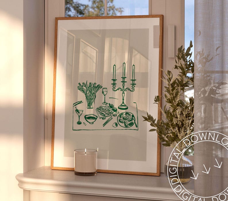 Puede incluir: Una impresi&oacute;n enmarcada de un dibujo de l&iacute;nea verde de una mesa puesta con un candelabro, flores, vasos y platos de comida. La impresi&oacute;n est&aacute; sobre un fondo gris claro y est&aacute; enmarcada en un marco de madera claro.
