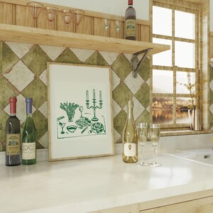 Puede incluir: Una ilustraci&oacute;n enmarcada en verde y blanco de una mesa puesta con velas, copas de vino y un plato de comida. La ilustraci&oacute;n est&aacute; sobre un fondo blanco y est&aacute; enmarcada en un marco de madera sencillo.