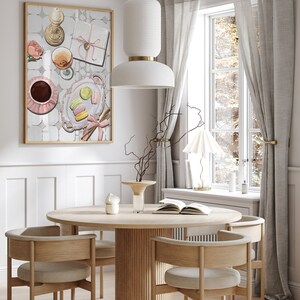 May include: A round wooden dining table with four chairs, a white pendant light, and a framed print of a still life with coffee, pastries, and a gift box. The table is set with a book and a vase with dried branches.