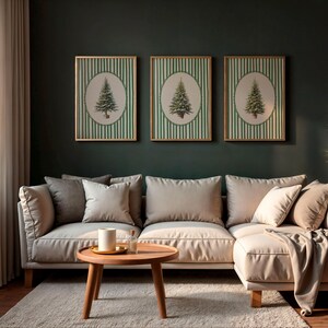 May include: Three framed wall art pieces featuring a green Christmas tree design on a striped background. The art hangs above a beige sectional sofa with pillows. A round wooden coffee table and a rug complete the living room setting.