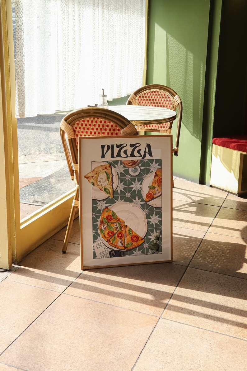 May include: A framed poster with the word "PIZZA" in a retro font. The poster features a close-up of three slices of pizza on a green and white tiled surface.