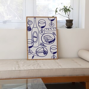 May include: A framed illustration of a wine bottle, glasses, cheese, and bread. The illustration is in blue on a white background.