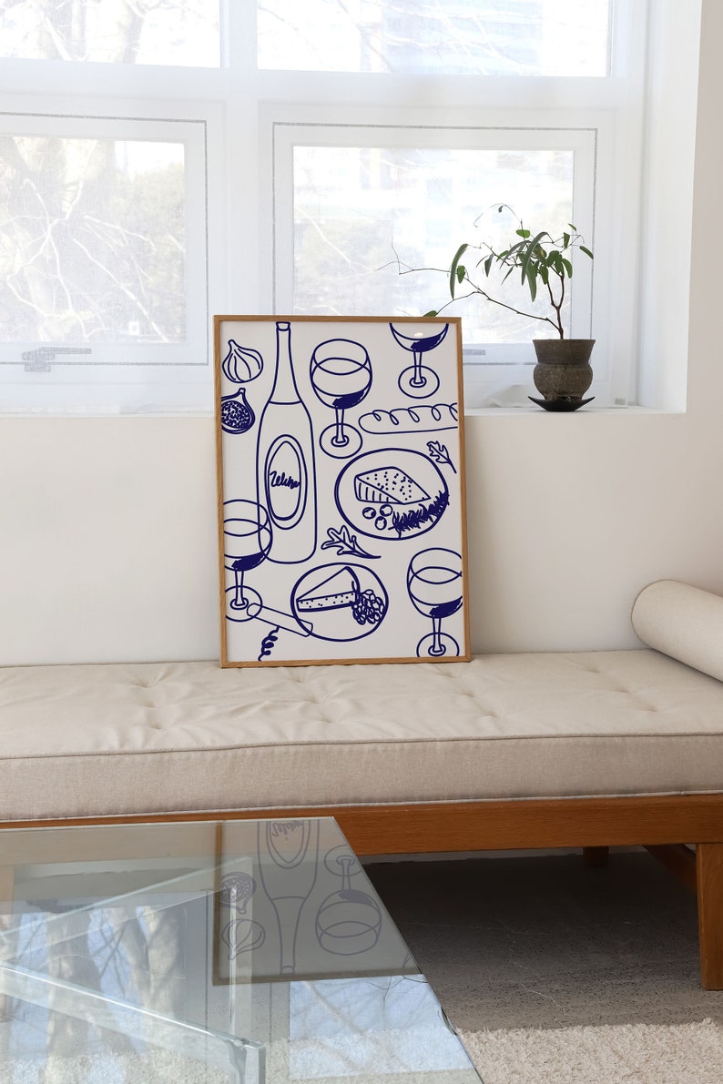 May include: A framed illustration of a wine bottle, glasses, cheese, and bread. The illustration is in blue on a white background.