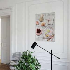 May include: A painting of a still life with a pink and white teacup, a glass of wine, a wrapped gift, a candle, and macarons on a plate. The background is a light gray with a pattern of squares.