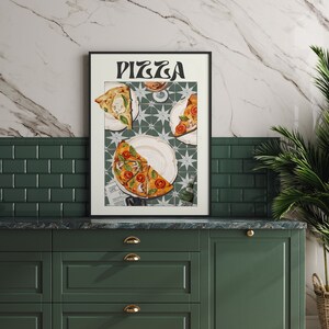 May include: A framed print with the word "PIZZA" in a retro font. The print features a still life of three slices of pizza on a white plate with a green and white tiled background.