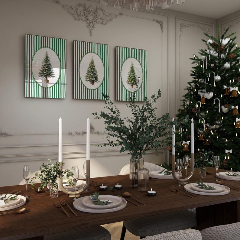 May include: A festive Christmas dining scene. Three framed artworks with green striped backgrounds and Christmas tree images hang above a table set for a holiday meal. A decorated Christmas tree and candles complete the holiday ambiance.