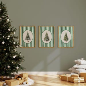 May include: Three framed Christmas tree prints with green and white striped backgrounds. Each print features a detailed illustration of a fir tree within an oval frame. A decorated Christmas tree and wrapped gifts are in the foreground.