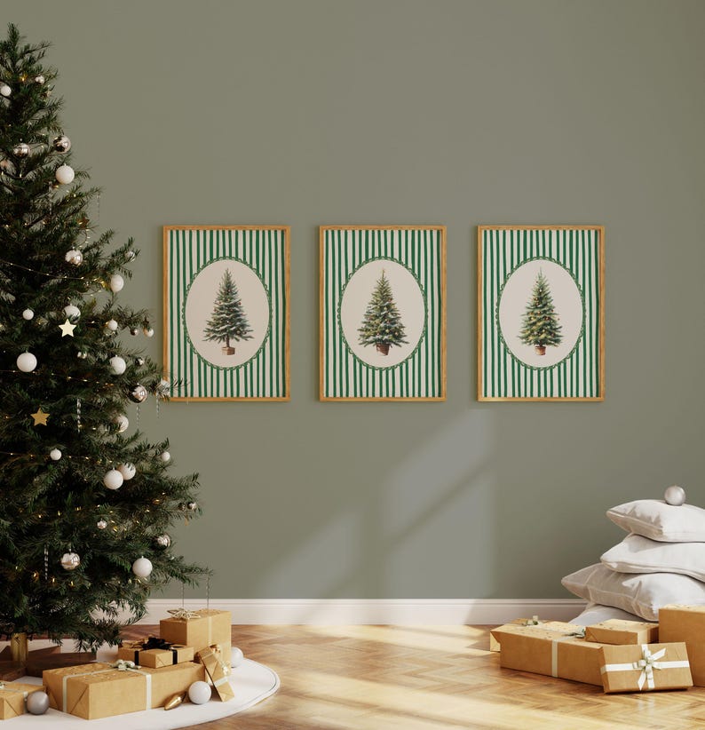 May include: Three framed Christmas tree prints with green and white striped backgrounds. Each print features a detailed illustration of a fir tree within an oval frame. A decorated Christmas tree and wrapped gifts are in the foreground.