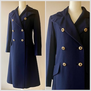 May include: A navy blue double-breasted coat with gold buttons. The coat features a notched collar and two front pockets. The coat is displayed on a mannequin. The coat's length is approximately 120 cm.
