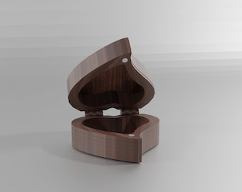 Puede incluir: Una caja de madera en forma de corazón con la tapa abierta, revelando un interior vacío. La caja está hecha de madera marrón oscura con un acabado liso.