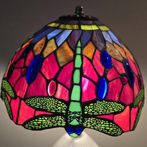 Tiffany-style stained glass lampshade,  vibrant red, blue, and green dragonfly design