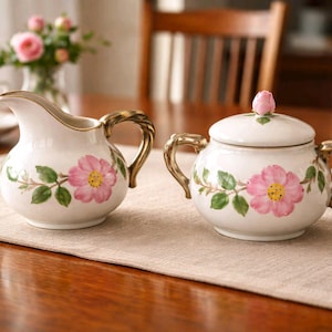 May include: A set of three ceramic mugs with a speckled, matte finish. The mugs are in shades of cream, light gray, and dark gray. Each mug has a simple, modern design and a rounded handle. The mugs are stacked on top of each other.