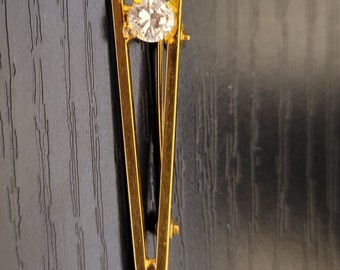 Narrow V shaped gold toned pin with solitaire crystal "diamond"