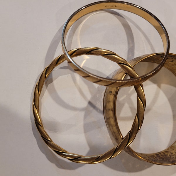 Lot of three gold toned vintage bangle bracelets, one signed Monet