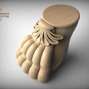 May include: A detailed, unfinished wooden carving of a foot, featuring a rounded top and ornate, layered details. The carving is light brown and displays the text "Wonderful Carving".