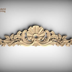 May include: A light-colored wooden decorative carving featuring a central shell motif flanked by symmetrical scrolling acanthus leaves and floral elements. The top left corner displays a logo with the text Wonderful Carving.