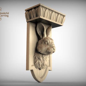 Puede incluir: Estante de pared de madera con una cabeza de conejo tallada. El estante tiene una parte superior decorativa con tallas en forma de hoja y una base en forma de escudo. El texto "Wonderful Carving" es visible.
