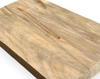 May include: A piece of light brown wood with a natural grain pattern. The wood has a smooth surface and is rectangular in shape.