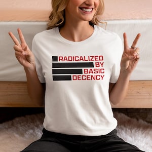 Op de afbeelding: Wit T-shirt met zwarte en rode tekst die "Geradicaliseerd door basis fatsoen" zegt.