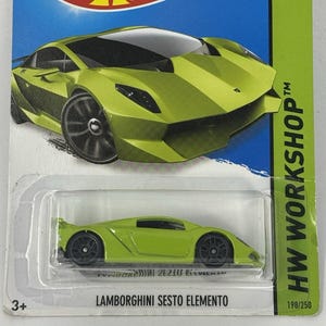 May include: A lime green Lamborghini Sesto Elemento die-cast toy car on a blue and green Hot Wheels card. The card features the Hot Wheels logo, "SHOWDOWN SCAN & RACE!", and "HW WORKSHOP". The car is labeled "198/250".