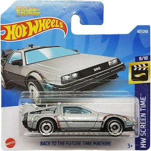 Puede incluir: Un modelo de coche de juguete Hot Wheels plateado del DeLorean de la película "Regreso al Futuro". El coche tiene detalles en negro y rojo. El embalaje incluye el texto "BACK TO THE FUTURE TIME MACHINE" y el logotipo de Hot Wheels.