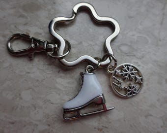 May include: Silver key chain with a star-shaped ring, a white ice skate charm, and a charm with snowflake designs.