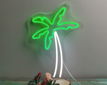Könnte beinhalten: Ein Neon-Schild in Form einer Palme mit grünen Blättern und einem weißen Stamm. Das Schild ist auf einem klaren Acrylsockel montiert.