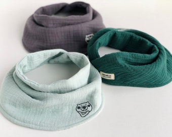 Puede incluir: Tres baberos para bebé en diferentes colores: verde claro, verde oscuro y gris. El babero verde claro tiene un pequeño diseño de oso. El babero verde oscuro tiene una etiqueta que dice "Baby Moller".