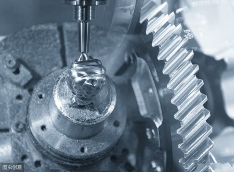 May include: Close-up of a metal gear being machined by a CNC milling machine. The gear is being cut by a rotating tool, leaving a shiny, metallic finish.