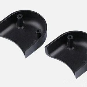 May include: Two black plastic half-circle shaped pieces with a small raised nub on each piece.