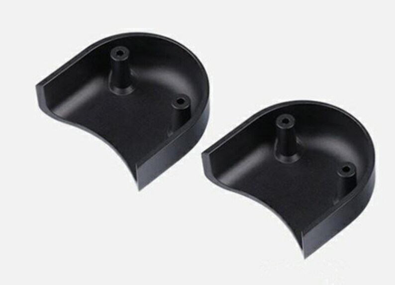 May include: Two black plastic half-circle shaped pieces with a small raised nub on each piece.