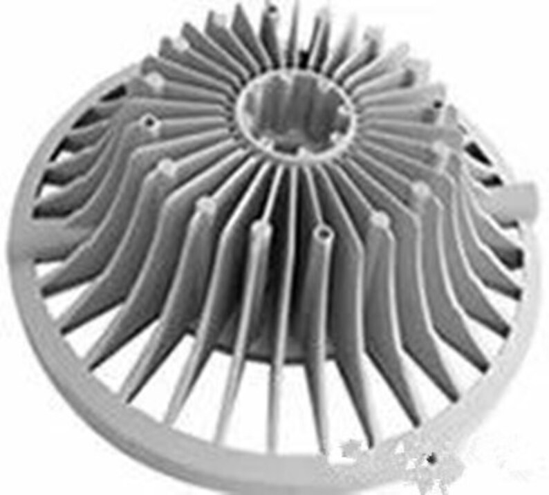 May include: A silver metal heat sink with a circular base and a series of radiating fins. The fins are arranged in a radial pattern and are designed to dissipate heat.