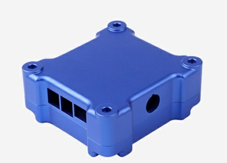 May include: A blue aluminum case with a rectangular shape and rounded edges. The case has a series of rectangular openings on one side and a circular opening on another side.
