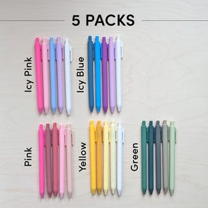 May include: Five packs of colorful gel pens in various shades of pink, blue, yellow, and green. The pens are arranged in rows with the color names written below each row. The text "5 PACKS" is written at the top of the image.