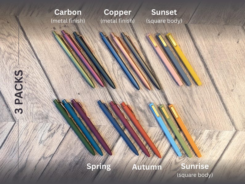 May include: A set of 3 packs of pens in various colors and finishes, including carbon, copper, sunset, spring, autumn, and sunrise. The pens are arranged in rows on a wooden surface.