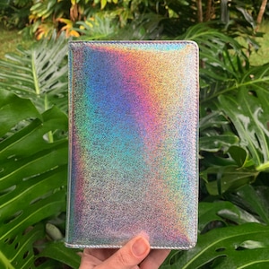 May include: A silver iridescent notebook cover with a subtle sparkle finish.