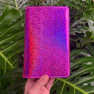 May include: A pink iridescent glitter wallet with a smooth, shiny finish.