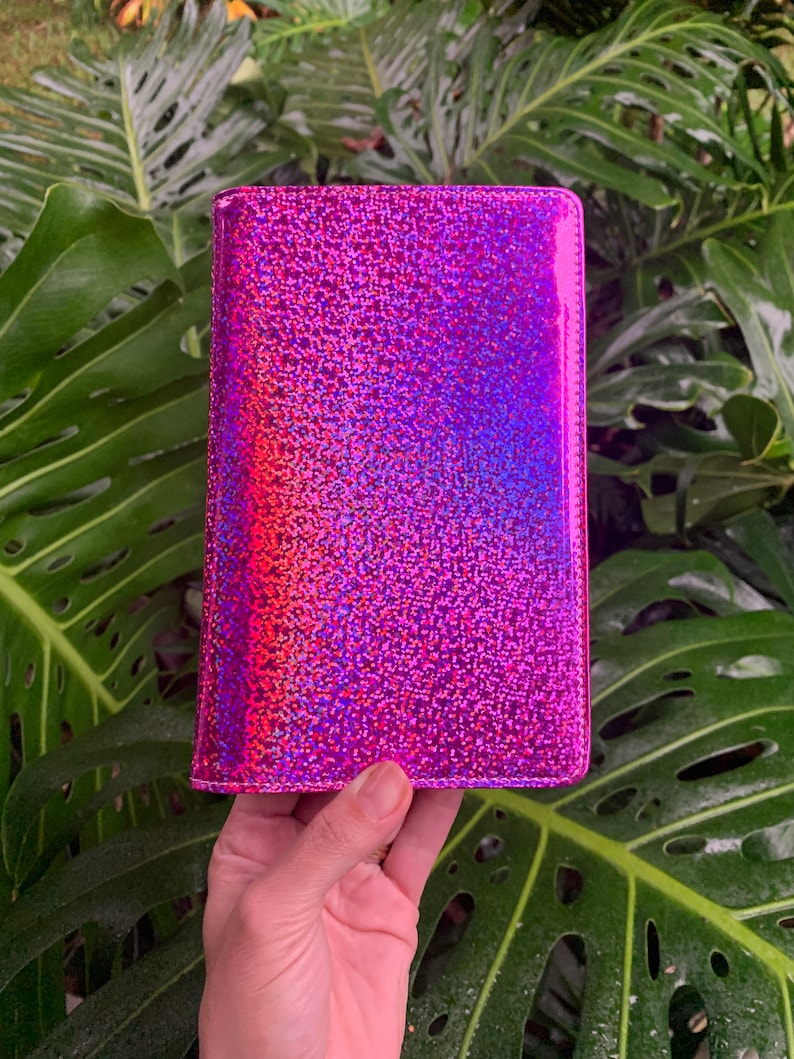 May include: A pink iridescent glitter wallet with a smooth, shiny finish.