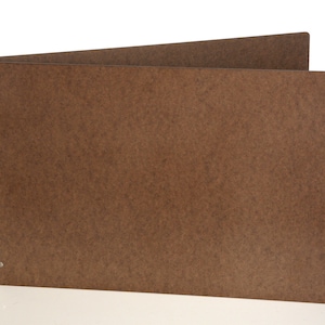 May include: A brown, three-ring binder with a textured surface. The binder is open, revealing the interior pages. The binder has three metal rings and is designed to hold paper. The background is white.