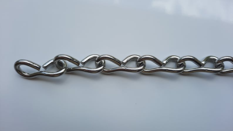 Stainless steel jack chain for hanging signs etc. Shown laying on a table close up view.
