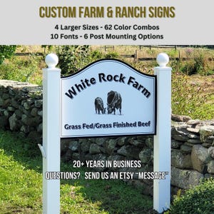 Puede incluir: Un letrero personalizado para granjas y ranchos montado sobre dos postes blancos con remates esf&eacute;ricos. El letrero muestra el texto White Rock Farm, una ilustraci&oacute;n de dos vacas y el texto Grass Fed/Grass Finished Beef, junto a m&aacute;s informaci&oacute;n.