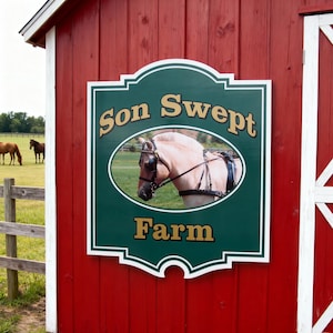 Puede incluir: Un letrero rectangular verde con borde blanco y bordes decorativos montado en una pared roja. El letrero presenta el texto "Son Swept Farm" en letras doradas y una imagen ovalada central de un caballo de color claro con arn&eacute;s negro.