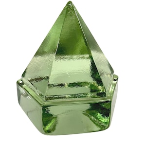 Op de afbeelding: Een lichtgroen glazen object met een zeshoekige basis en een puntige, piramidevormige bovenkant. Het oppervlak van het glas heeft een reflecterende, metallic glans, wat zorgt voor een glad en gepolijst uiterlijk met scherpe randen.
